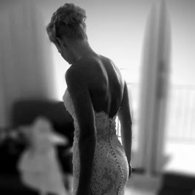 Kendra on her wedding day, photographed from behind in a fitted lace gown, in black and white